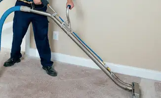 Professional operating a liquid removal machine on a carpeted floor in Jacksonville, FL